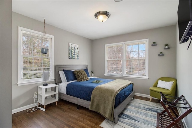 bedroom with dark hardwood / wood-style floors and multiple windows