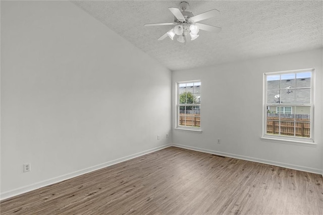 1910 Towne Park Dr, Mcdonough, GA 30252 - spare room featuring a textured ceiling, wood finished floors, baseboards, ceiling fan, and lofted ceiling