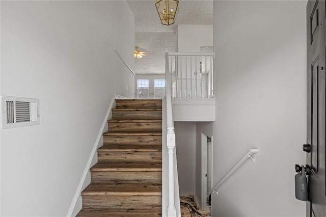 1910 Towne Park Dr, Mcdonough, GA 30252 - staircase featuring a high ceiling, a chandelier, and baseboards
