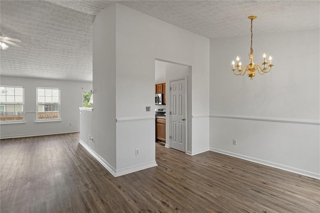 1910 Towne Park Dr, Mcdonough, GA 30252 - spare room featuring a textured ceiling, dark wood-type flooring, a chandelier, a ceiling fan, and baseboards