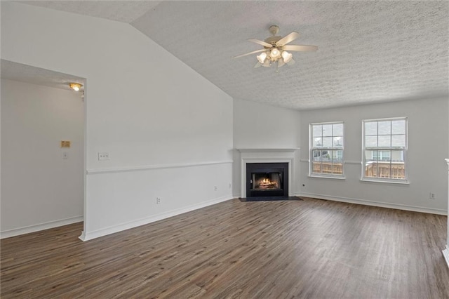 1910 Towne Park Dr, Mcdonough, GA 30252 - unfurnished living room featuring a fireplace with flush hearth, ceiling fan, wood finished floors, vaulted ceiling, and a textured ceiling