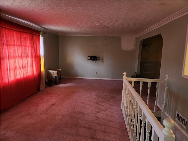 unfurnished room with ornamental molding, a textured ceiling, and carpet flooring