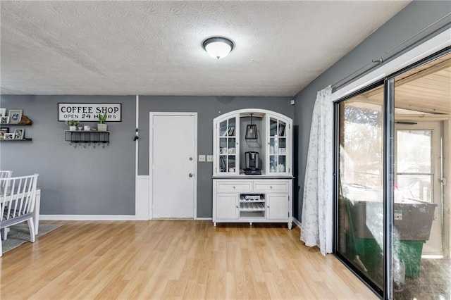 interior space with a textured ceiling and light hardwood / wood-style flooring