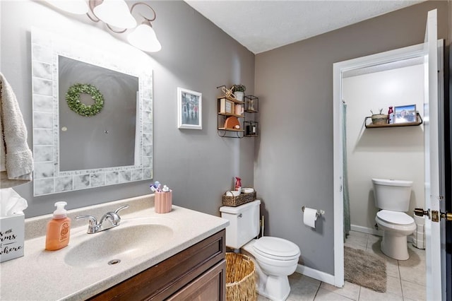 bathroom with toilet, tile patterned floors, and vanity