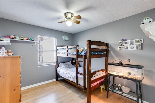 bedroom featuring ceiling fan, a textured ceiling, and light hardwood / wood-style flooring