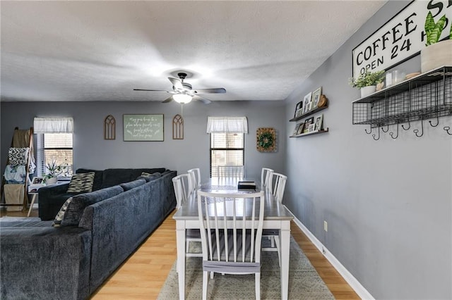 dining area with a textured ceiling, ceiling fan, and hardwood / wood-style flooring