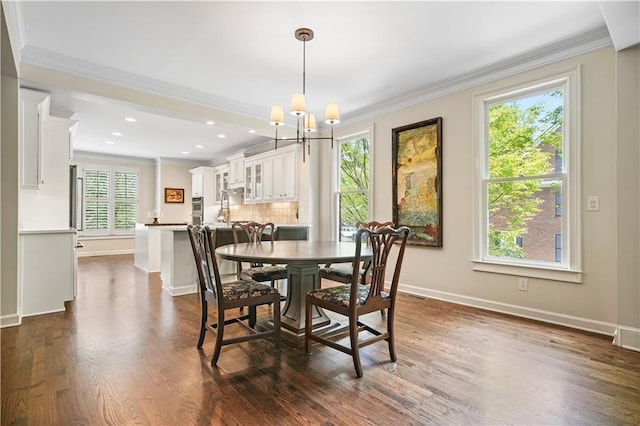 dining space with dark hardwood / wood-style floors, a chandelier, and crown molding