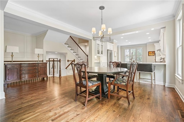 dining room featuring ornamental molding, wood-type flooring, and a chandelier