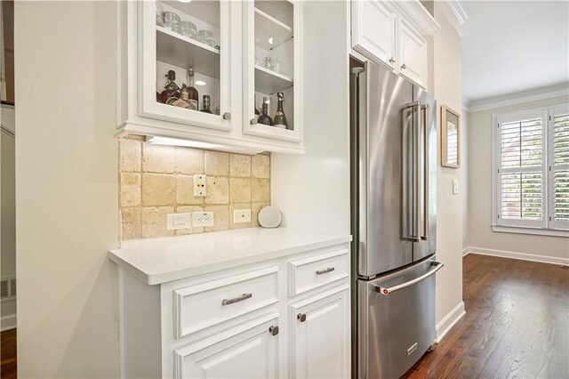 kitchen featuring white cabinetry, tasteful backsplash, high quality fridge, crown molding, and dark wood-type flooring