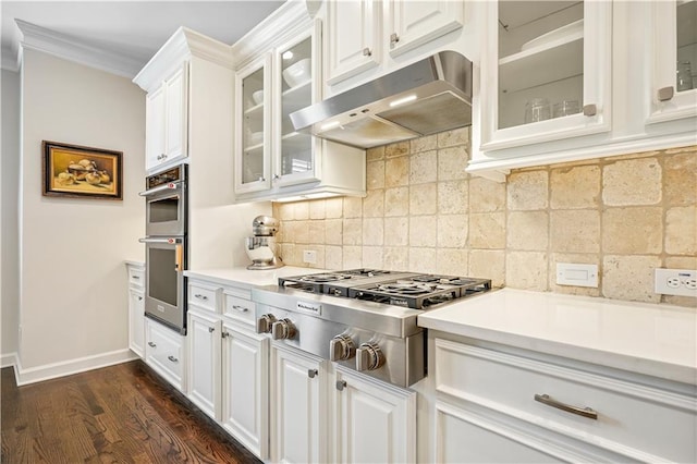 kitchen featuring dark wood-type flooring, white cabinetry, appliances with stainless steel finishes, and decorative backsplash