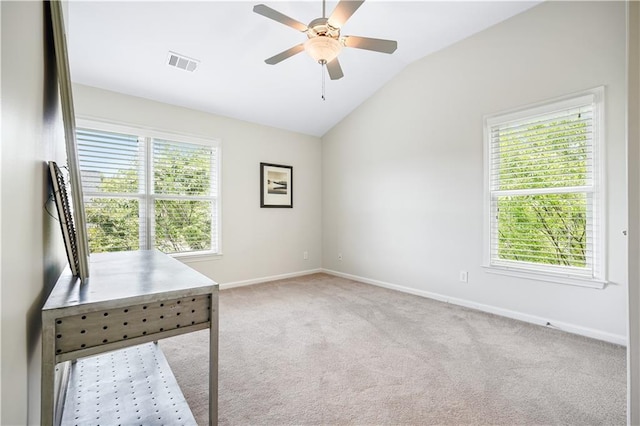 unfurnished office with light carpet, ceiling fan, and vaulted ceiling