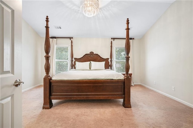 carpeted bedroom featuring multiple windows, an inviting chandelier, and lofted ceiling