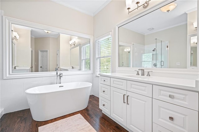 bathroom with wood-type flooring, vanity, plus walk in shower, crown molding, and tile walls