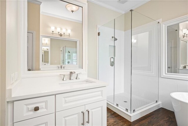 bathroom featuring wood-type flooring, tile walls, ornamental molding, vanity, and independent shower and bath