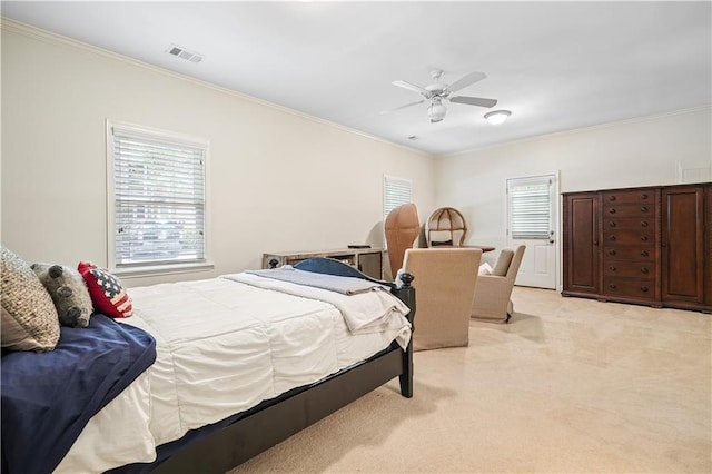 carpeted bedroom featuring ceiling fan and crown molding