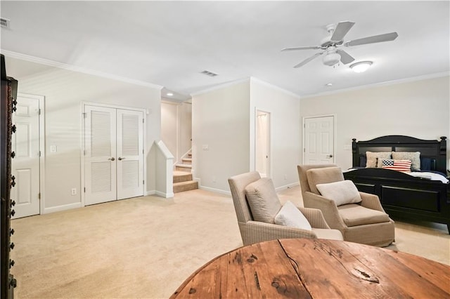 bedroom featuring two closets, light carpet, ceiling fan, and crown molding