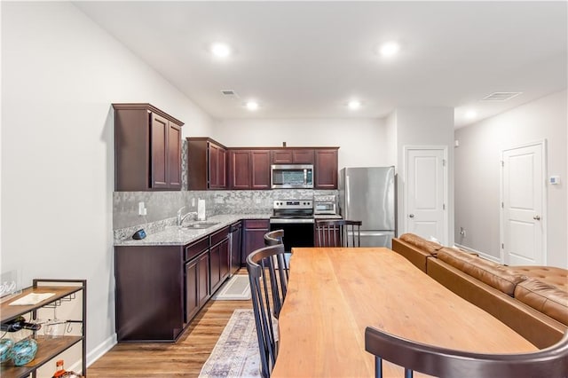 244 Grand Central Way, Cartersville, GA 30120 - kitchen featuring appliances with stainless steel finishes, light wood-type flooring, decorative backsplash, a sink, and recessed lighting