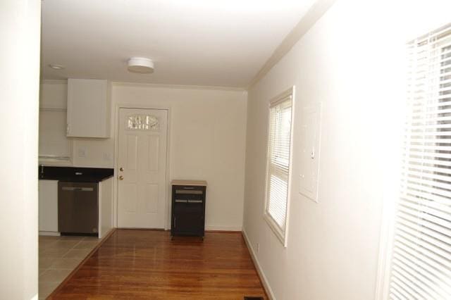 kitchen with white cabinets, dishwasher, and wood finished floors