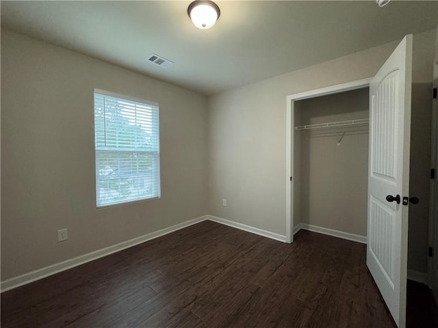 241 Coral Cir, Mcdonough, GA 30253 - unfurnished bedroom featuring dark wood finished floors, baseboards, and a closet
