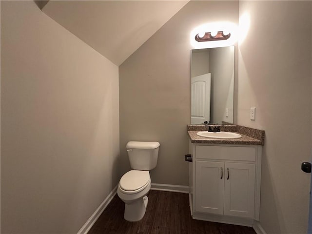 241 Coral Cir, Mcdonough, GA 30253 - half bath with lofted ceiling, wood finished floors, toilet, vanity, and baseboards