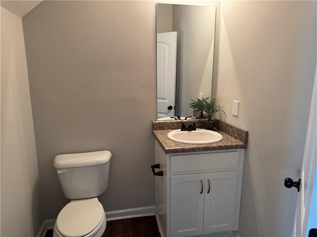 241 Coral Cir, Mcdonough, GA 30253 - bathroom featuring vanity, toilet, baseboards, and wood finished floors
