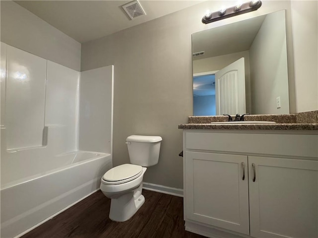 241 Coral Cir, Mcdonough, GA 30253 - full bathroom featuring wood finished floors, toilet, vanity, baseboards, and bathtub / shower combination
