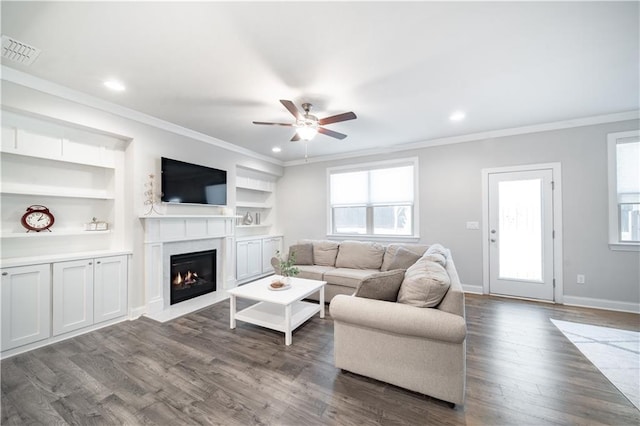 living room featuring built in features and crown molding