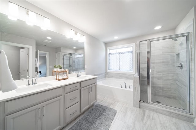 bathroom featuring separate shower and tub and vanity