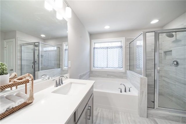 bathroom with vanity and independent shower and bath