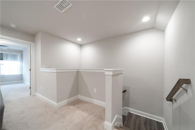 corridor with light carpet and lofted ceiling