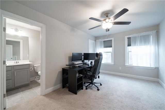 carpeted office featuring ceiling fan and sink