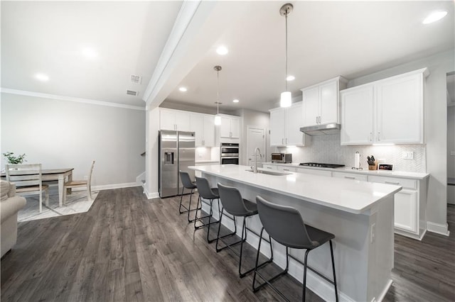 kitchen featuring white cabinets, appliances with stainless steel finishes, a center island with sink, and sink