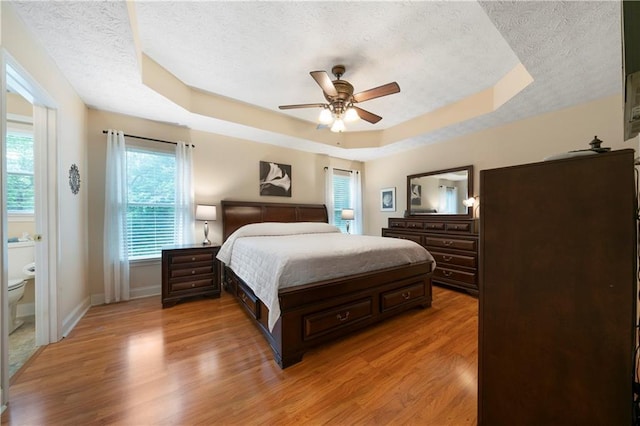 2281 Carlan Rd, Jasper, GA 30139 - bedroom featuring a textured ceiling, a raised ceiling, light wood-style flooring, baseboards, and ceiling fan