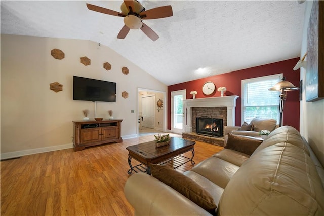 2281 Carlan Rd, Jasper, GA 30139 - living area with baseboards, light wood-style flooring, vaulted ceiling, a fireplace, and ceiling fan