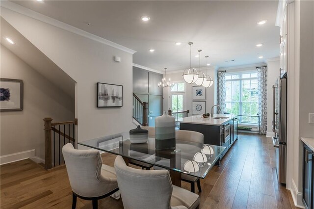 dining room with crown molding, dark hardwood / wood-style flooring, and sink