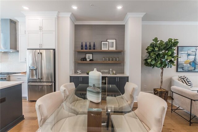 dining area featuring light hardwood / wood-style floors and ornamental molding