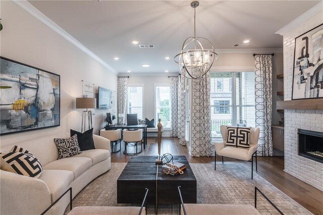 living room with crown molding, a fireplace, dark hardwood / wood-style flooring, and an inviting chandelier