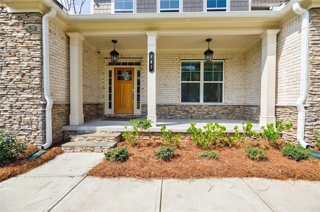 property entrance with covered porch and stone siding