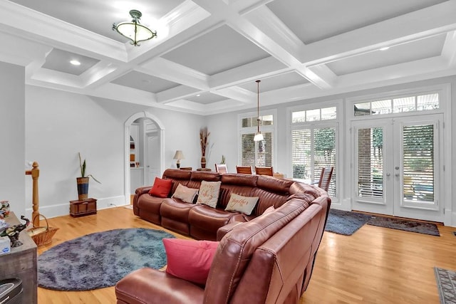 living room featuring beamed ceiling, light hardwood / wood-style flooring, coffered ceiling, and french doors