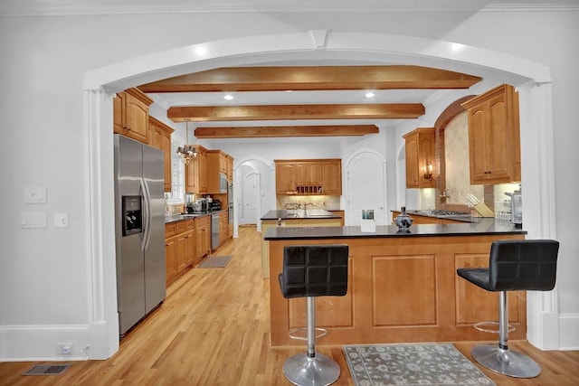 kitchen with light wood-type flooring, kitchen peninsula, backsplash, a kitchen breakfast bar, and stainless steel refrigerator with ice dispenser