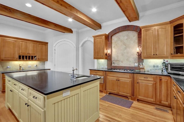 kitchen featuring decorative backsplash, beam ceiling, and sink