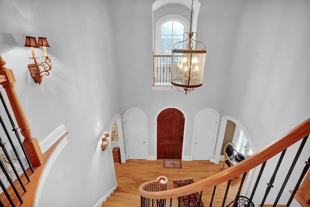 foyer featuring hardwood / wood-style flooring, a chandelier, and a high ceiling