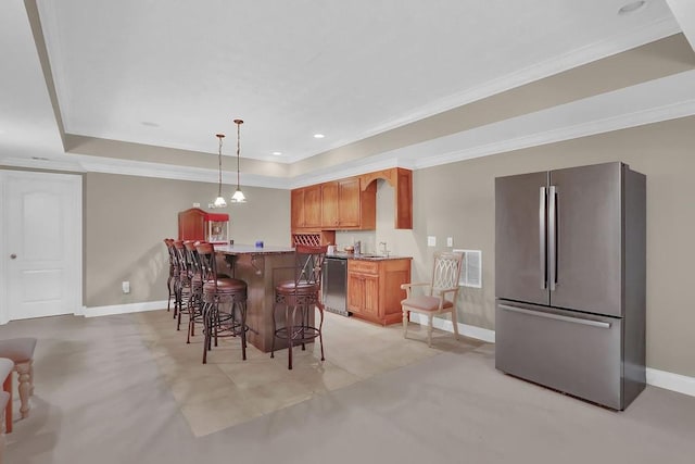 dining space featuring sink, a tray ceiling, and ornamental molding