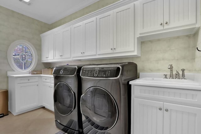 laundry area with sink, washer and dryer, cabinets, and light tile patterned floors