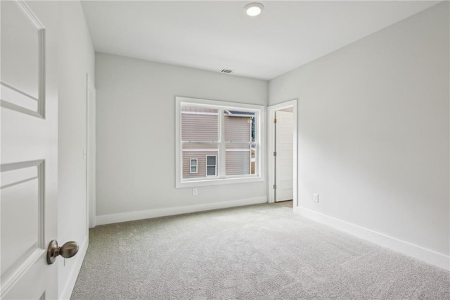 empty room featuring visible vents, baseboards, and carpet