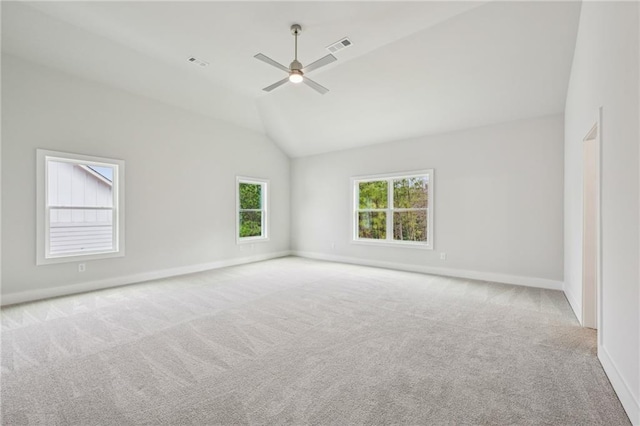 carpeted spare room featuring lofted ceiling, baseboards, visible vents, and ceiling fan