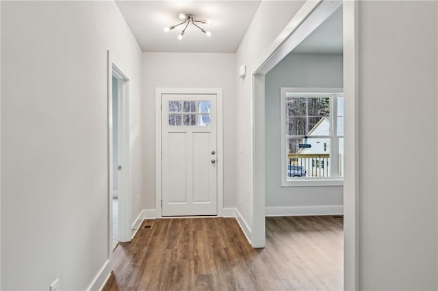 foyer entrance featuring baseboards and wood finished floors