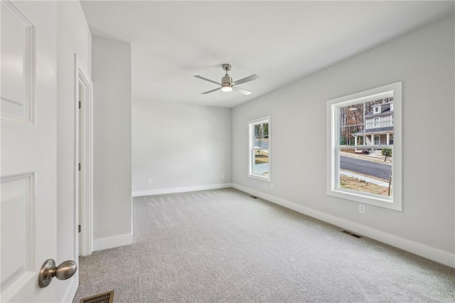 spare room featuring visible vents, carpet flooring, baseboards, and ceiling fan