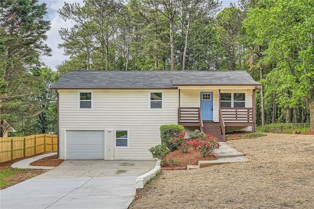 view of front of house with a porch, a garage, fence, and concrete driveway