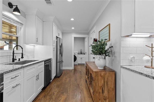 kitchen featuring white cabinetry, washer / dryer, stainless steel fridge with ice dispenser, a sink, and dishwasher